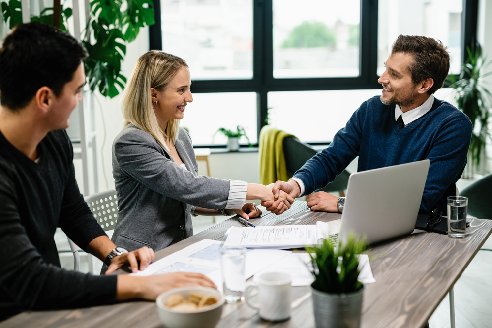 young-happy-couple-meeting-with-financial-advisor-office-woman-is-handshaking-with-agent